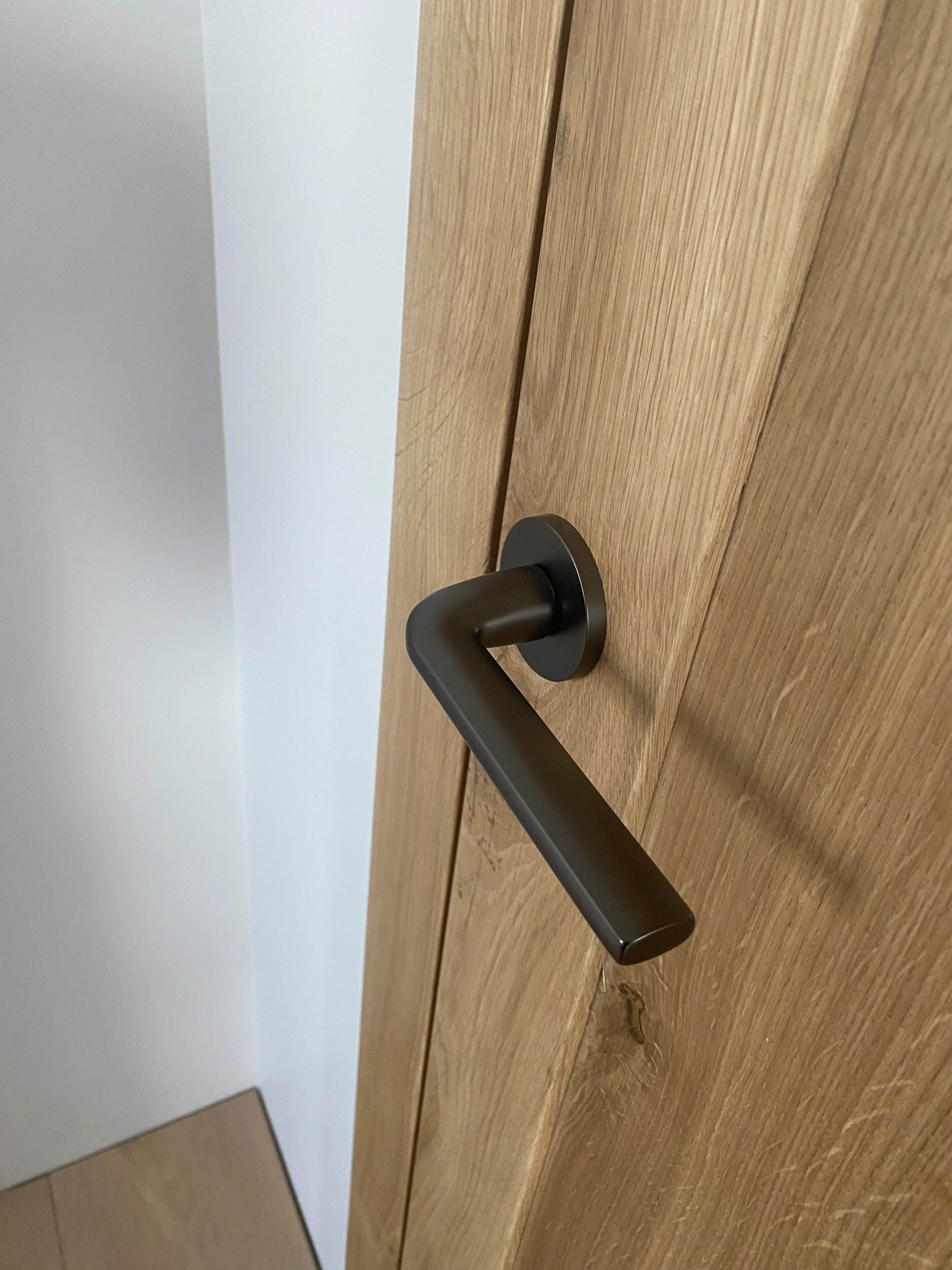 Detal klamka w kolorze gunmetal w dębowych drzwiach - realizacja Gliwice