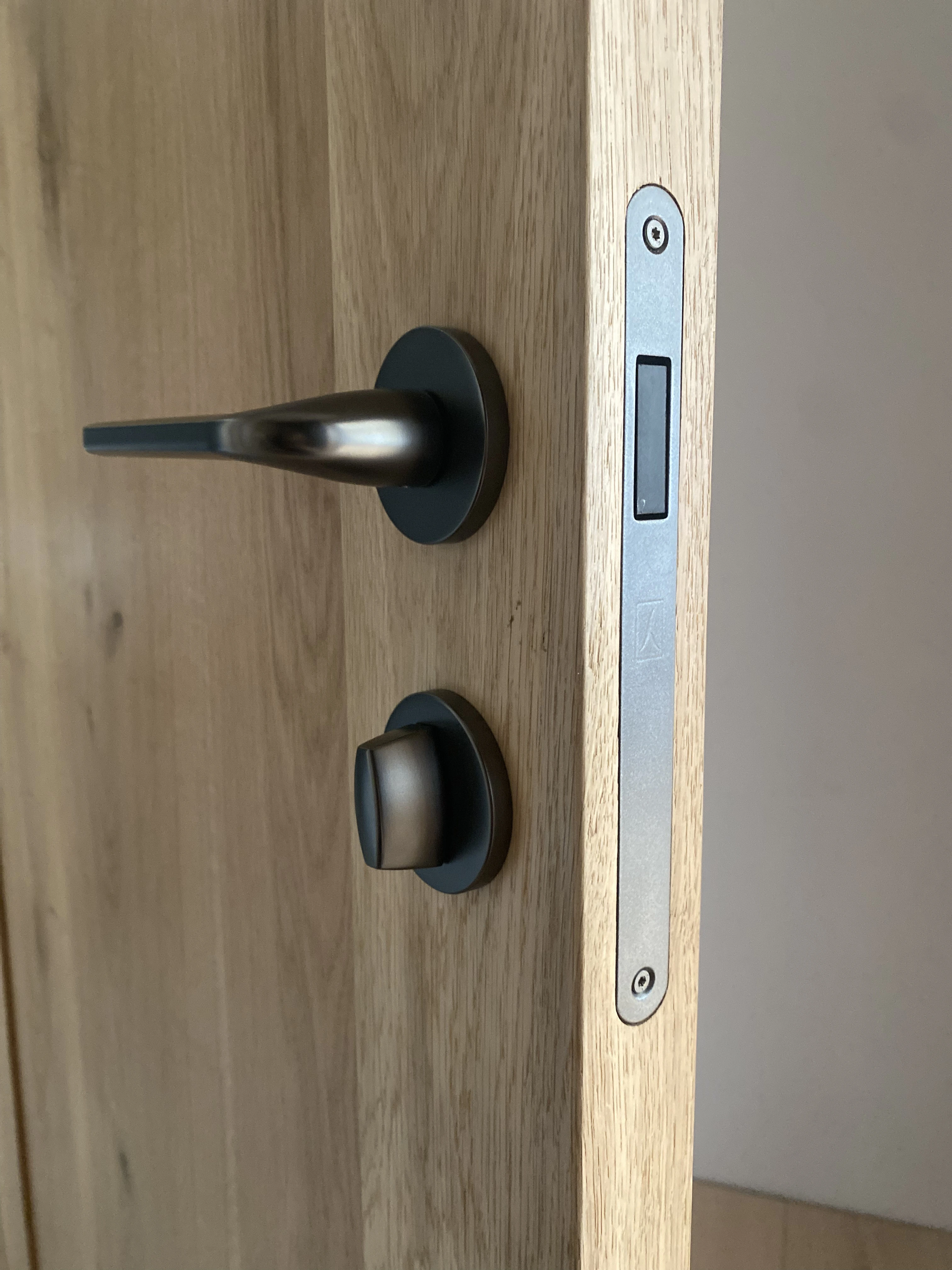 Detal okucia klamka i zamek kolor gunmetal w dębowych drzwiach - realizacja Gliwice