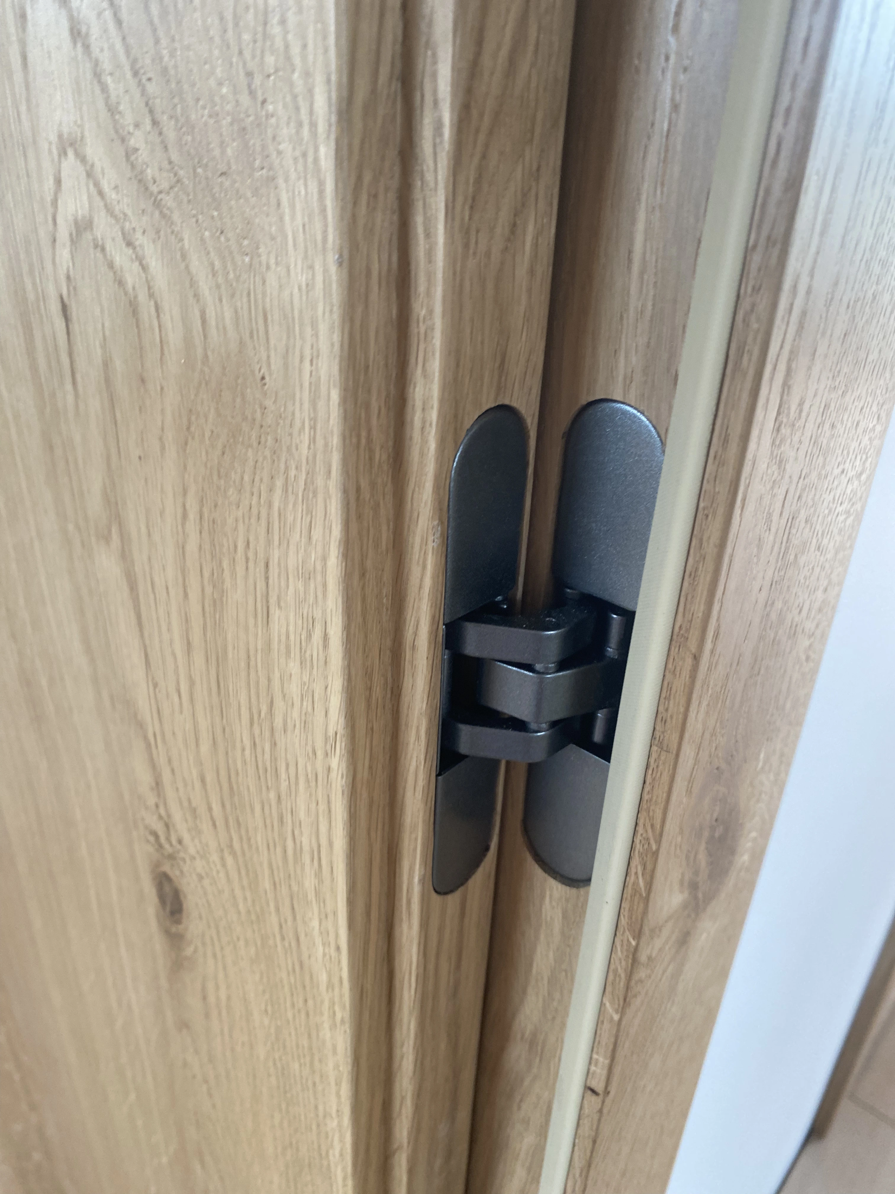 Detal zawias w kolorze gunmetal w dębowych drzwiach - realizacja Gliwice
